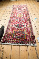Intact white fringe and vibrant geometric floral pattern of a hand-knotted vintage Karaja rug.