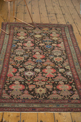 Antique Malayer rug detail: rose and blue potted plants, starbursts, and a mir boteh border.