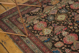Charcoal field with potted plants and starbursts on an antique Malayer rug, blush rose border.