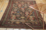 Antique Malayer rug detail: cochineal red mir boteh border, charcoal field, blush rose plant motifs, wear.