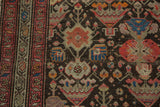 Antique Malayer rug's mir boteh main border and dark field with blush rose, blue, and orange motifs.