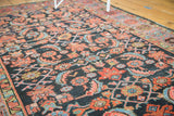 Serrated herati pattern details in terra cotta, blush, sky blue on dark indigo field.
