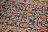 Intricate herati pattern in terra cotta and sky blue on the indigo Hamadan rug.
