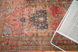 Blush rose field, blue medallion, and ornate border of vintage Farahan Sarouk rug.