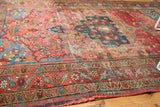 Blush rose and blue floral field and border with exposed foundation and tattered fringe.