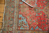 Farahan Sarouk rug detail showing blush rose, pale sky blue, exposed foundation, and edge wear.