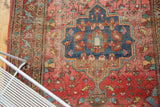 Saturated blush rose field and vivid blue medallion on a vintage Persian rug.