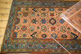 Intricate floral vinery on peach apricot field and blue border of antique Persian Lilihan rug.
