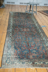 Close view of the vintage Persian runner's allover floral design in blue, red, and ivory.