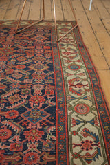 Antique Hamadan runner's ivory border with blush, green stylized patterns, and indigo field.