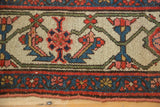 Traditional Persian Hamadan border detail with indigo, red, and blush floral patterns and wear.