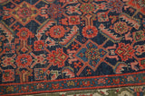 Antique Hamadan rug's indigo field with herati motif and blush floral border.