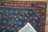 Vintage Hamadan rug corner: aqua blue field, intricate Herati pattern, madder red border.