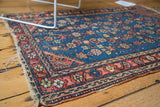 Finely woven vintage Persian Hamadan rug border with madder root red and intricate details, showing tattered fringe.