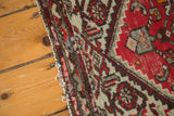 Vintage Hamadan rug edge with tattered ends, geometric patterns, red, ivory, and blue detail.