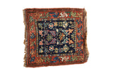 Vintage Kurdish Bag Face rug: indigo field, rust border, colorful geometric pinwheel motifs.