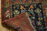 Folded vintage Kurdish Bag Face rug showing geometric pile, fringe, and its woven back.