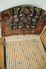 Light tatter on ivory fringe and rust geometric border of vintage Kurdish Bag Face rug.