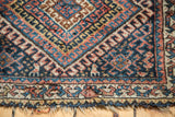 Navy, saffron, sky blue geometric motifs on antique Jaff Kurd rug border, with tattered end.