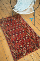 Hand-knotted vintage Turkmen rug corner featuring geometric patterns, secure ends, and brick red hues.