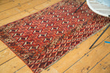 Brick red and navy geometric diamond pattern at the vintage Turkmen rug's end.