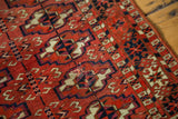 Vintage Turkmen rug's textured pile displaying geometric guls in brick red, dark navy, and antique ivory.