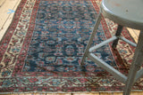 Vintage Persian Malayer rug detail: Herati motif, indigo field, cochineal red border, and even wear.