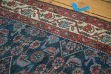 Worn indigo Herati motif and cochineal red, antique ivory border of a Malayer rug.