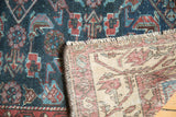 Vintage Malayer rug: indigo Herati pile, hand-knotted ivory foundation, and short fringe.