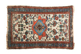 Vintage Malayer rug with vibrant terra cotta, sky blue, and mallard green floral motifs on ivory.