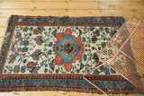 Diagonal view of a playful vintage Malayer rug with terra cotta and sky blue florals.