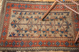 Antique Belouch rug with splayed floral, barber pole motifs, in natural camel and madder red.