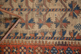 Natural camel hair Belouch rug: blue splayed floral motifs and madder red border.
