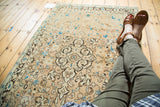 Vintage Sarouk rug's scrolling medallion and floral tendril field in ivory, peach, charcoal, blue.