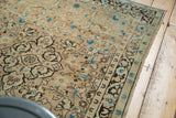 Hand-knotted edge and intricate floral border of the vintage Sarouk rug in ivory, peach, blue.