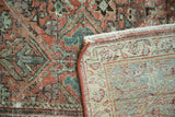 Vintage Mahal carpet detail with ruby red and blue floral pattern, revealing light foundation and fringe.