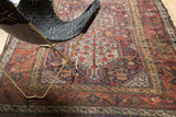 Hand-knotted Qashqai rug detail: pomegranate trees, vines, and botanical motifs in red, blue, gold, green.