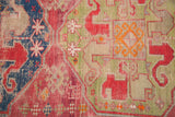 Brilliant gem green, cochineal red, and navy geometric motifs on antique Caucasian runner.