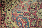 Antique Kermanshah rug detail: cochineal red and powder blue serrated motifs, worn knot heads.
