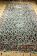 Antique Malayer rug end featuring repeating boteh, brick red border, and visible foundation wear.
