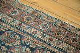 Detail of antique Malayer runner: repeating stylized patterns in brick red, navy, and cream tones.