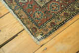 Detail of antique Malayer runner corner, showing fringe, secured edge, and wear.