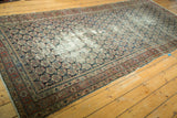 Detailed angled view of antique Malayer rug's intricate brick red border and repeating boteh pattern.