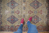 Detailed view of the threadbare texture and intricate pattern on an antique Kermanshah rug.