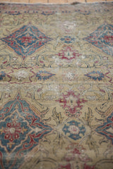 Threadbare pile revealing the ivory foundation of an antique hand-knotted Kermanshah rug.