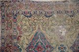 Detail of an antique Kermanshah's threadbare pile, showing the tattered edges and exposed cotton foundation.