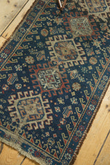 Geometric field and hooked motifs on vintage Afshar rug corner with fringe.
