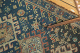 Detail of vintage Afshar rug: copper rod points to geometric motif with indigo patina.