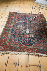 Vintage North West Persian rug's tattered fringe and geometric blush, brick red border, foundation showing.