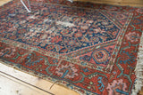 Tattered edge of the vintage North West Persian rug, showing foundation and red border.